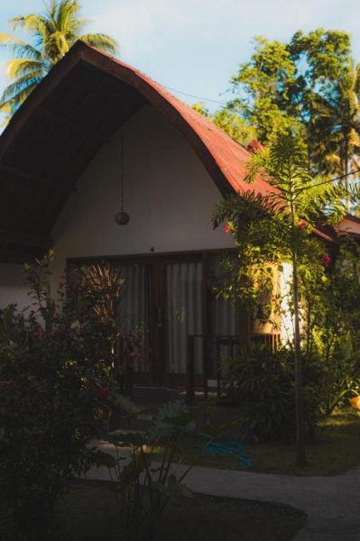 Bungalow con techo rojo rodeado de jardín tropical exuberante en el Hotel Twiny's