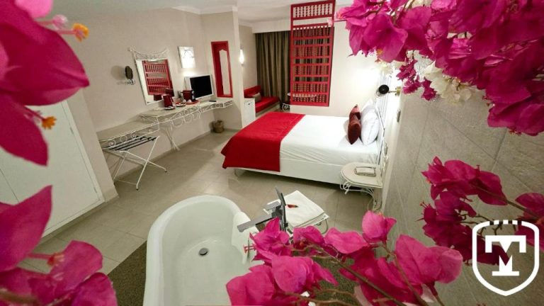 Habitación de lujo con bañera exenta y decoración floral en rojo del Hotel La Residence Hammamet