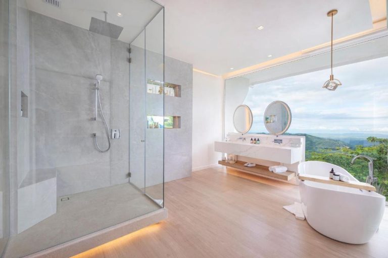 Baño de suite de lujo con bañera exenta, ducha de lluvia y vistas panorámicas en The Retreat Costa Rica