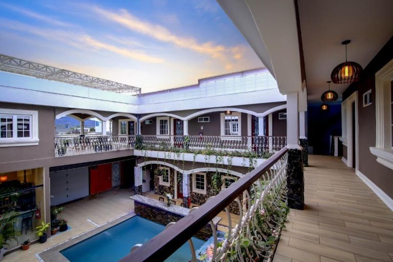 Patio interior con piscina y balcones decorados del Hotel Bugambilias al atardecer