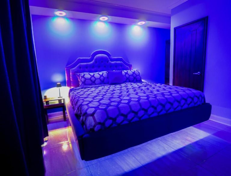 Habitación con cama doble e iluminación LED morada del Hotel Bugambilias