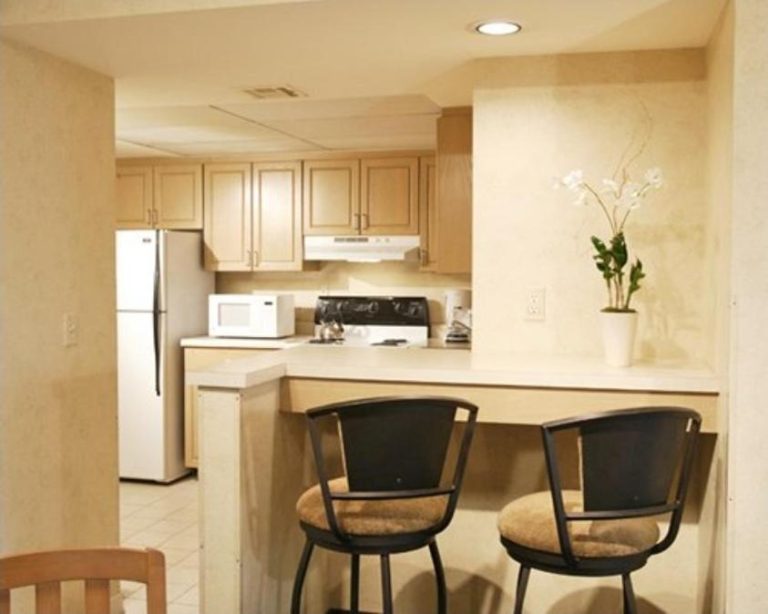 Cocina americana con barra y taburetes del hotel The Carriage House, equipada con electrodomésticos modernos