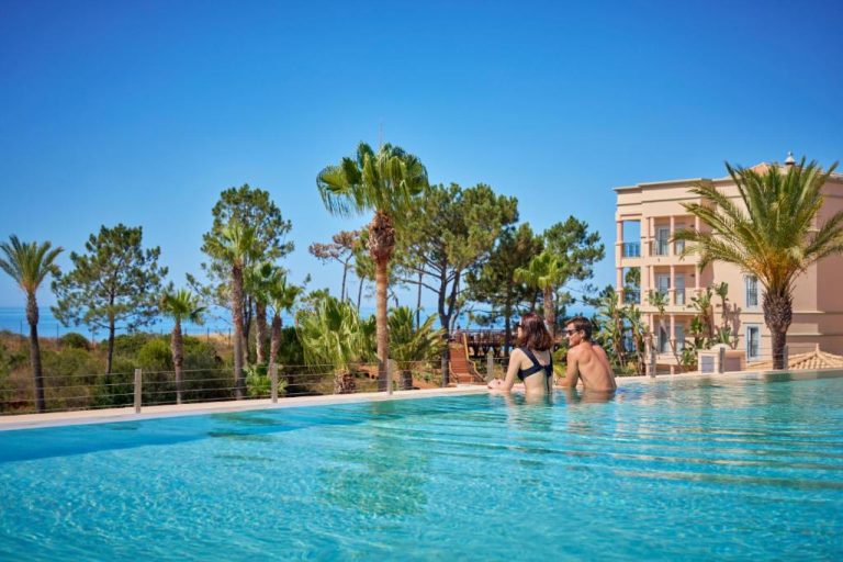 Pareja disfrutando de la piscina infinita con vistas al mar en el hotel PortoBay Blue Ocean