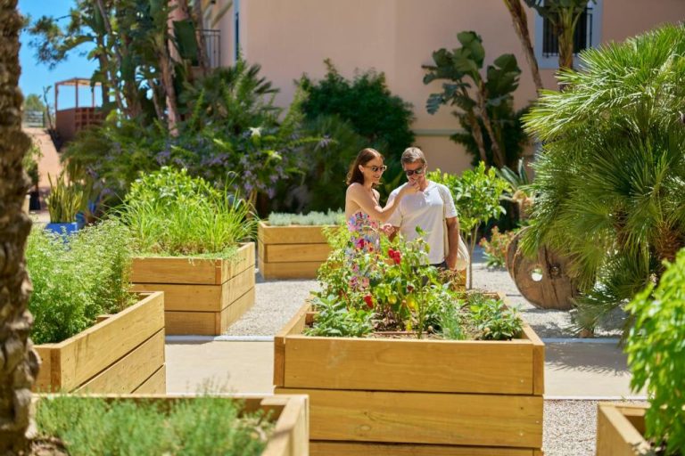 Pareja paseando entre huertos aromáticos y jardines del PortoBay Blue Ocean en un día soleado
