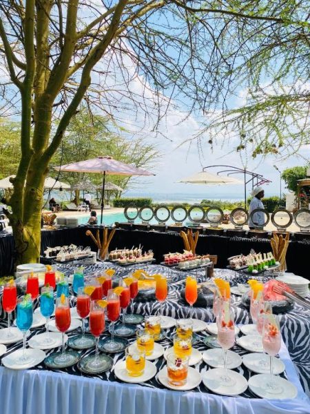 Buffet exterior con cócteles coloridos y postres junto a la piscina del Lake Elementaita Manor en Kenia