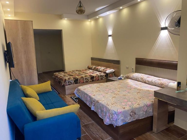 Habitación triple con cama doble, cama individual y sofá azul en Florenza Compound