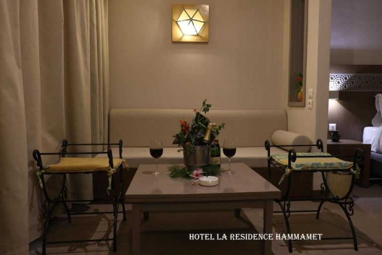 Salón romántico con copas de vino y champán en mesa del Hotel La Residence Hammamet