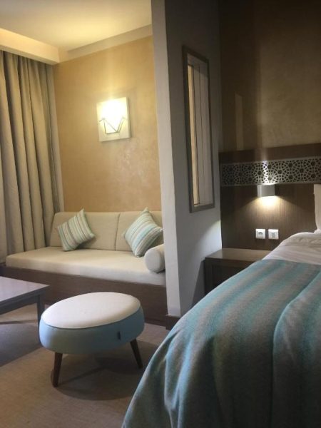 Habitación doble con zona de estar y sofá en Hotel La Residence Hammamet, Túnez