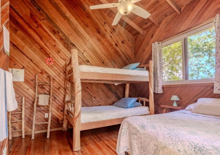 Habitación rústica con literas de madera y techo de cabaña en Guava Grove Resort & Villas