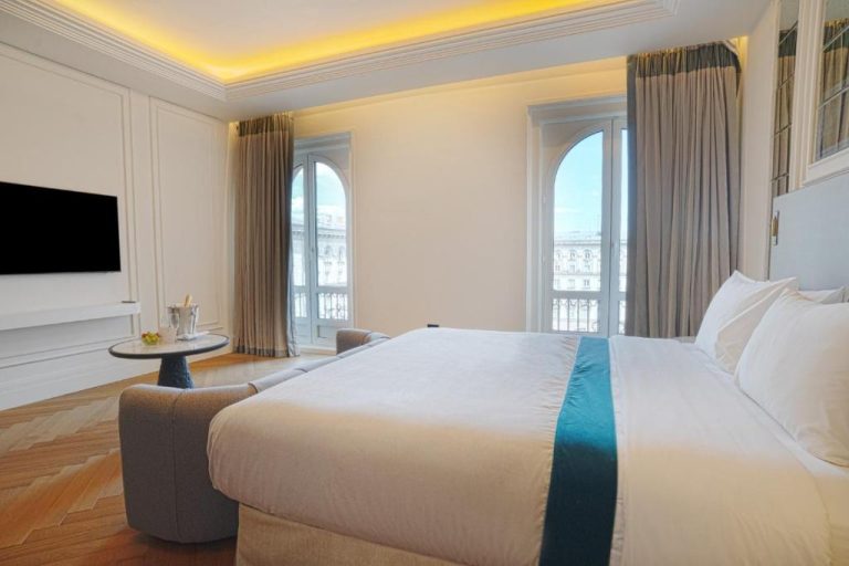 Suite de lujo con cama king size y vistas al exterior en el Sofia Balkan Palace Hotel