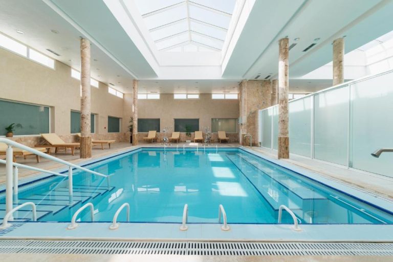 Piscina interior climatizada con tragaluz y tumbonas del Capsa Thermal Oasis Spa
