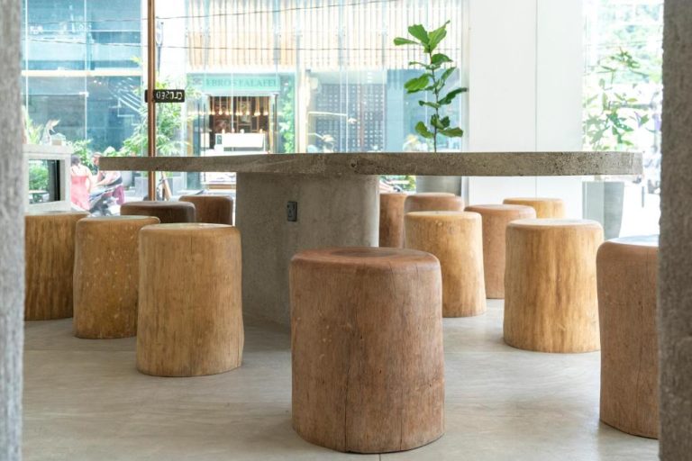 Área de comedor con taburetes de madera y mesa de cemento en S Resort El Nido, recién renovado