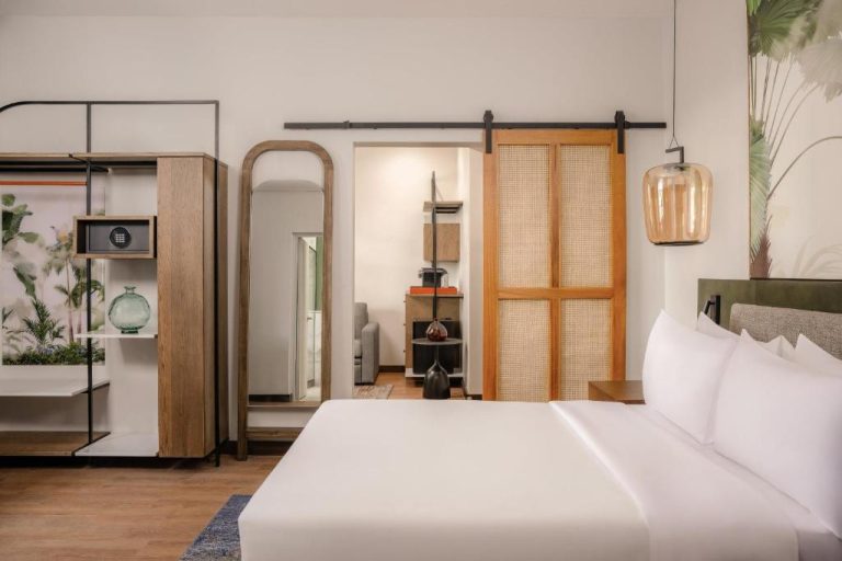 Habitación suite con cama king y puerta corredera de madera en Vignette Collection Fairview Hotel Nairobi