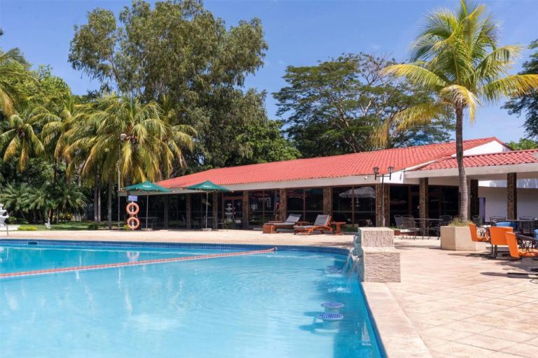 Piscina exterior con tumbonas y jardín tropical del Best Western Las Mercedes Airport Hotel