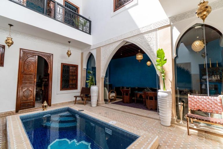 Patio interior con piscina y arcos árabes decorados del Riad Serendip en Marrakech