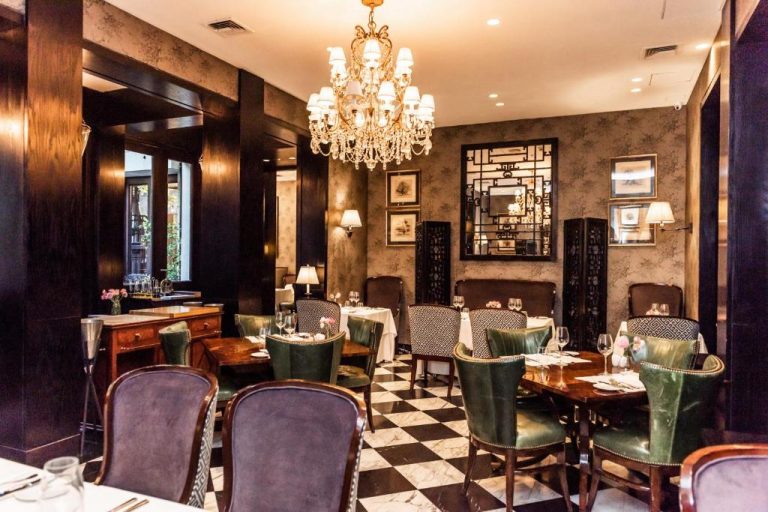 Elegante restaurante interior del The Singular Santiago con chandelier de cristal y suelo de mármol en damero
