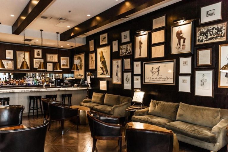 Elegante bar lounge con sofás de terciopelo y galería de arte en The Singular Santiago