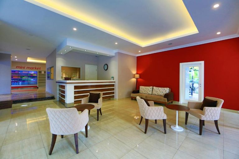 Recepción y lobby del Perle Apart Hotel con zona de espera, sillas tapizadas y mini market