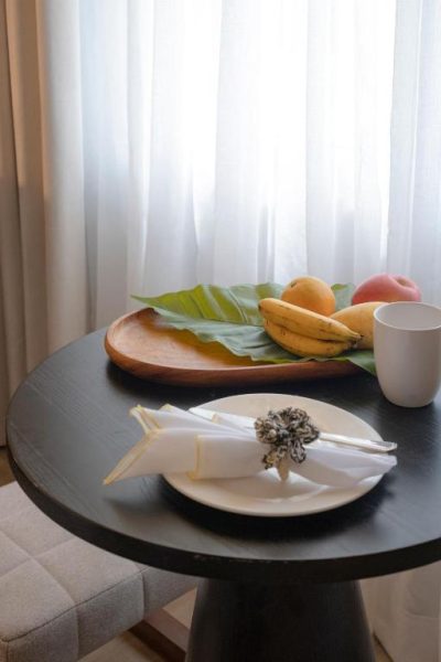 Mesa de bienvenida con frutas tropicales y vajilla elegante en el hotel Amari by Vivere Hospitality Group