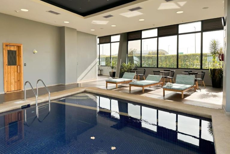 Piscina interior climatizada con tumbonas y zona de relax en el hotel Wyndham Quito Airport
