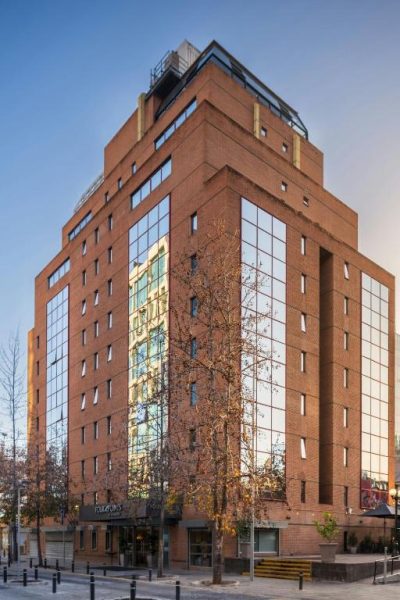 Fachada exterior del Four Points by Sheraton Santiago, edificio de ladrillo con ventanales en pleno centro de la ciudad