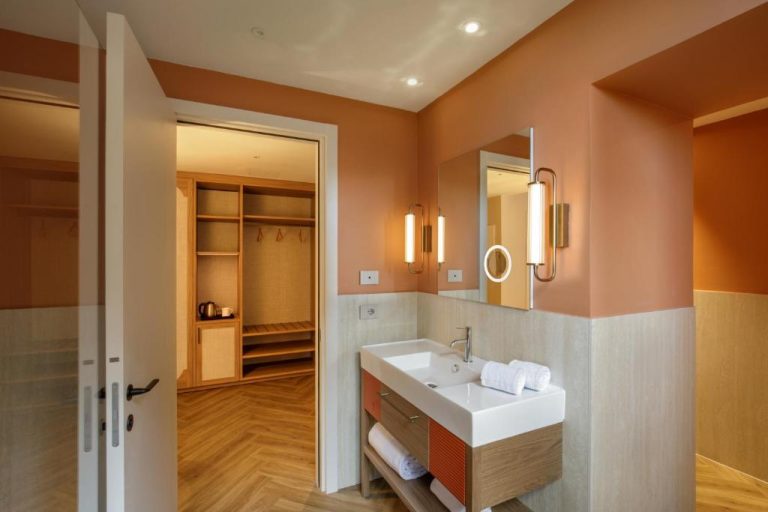 Baño moderno con lavabo doble y vestidor en el Rosetta Hotel Perugia Tapestry Collection by Hilton