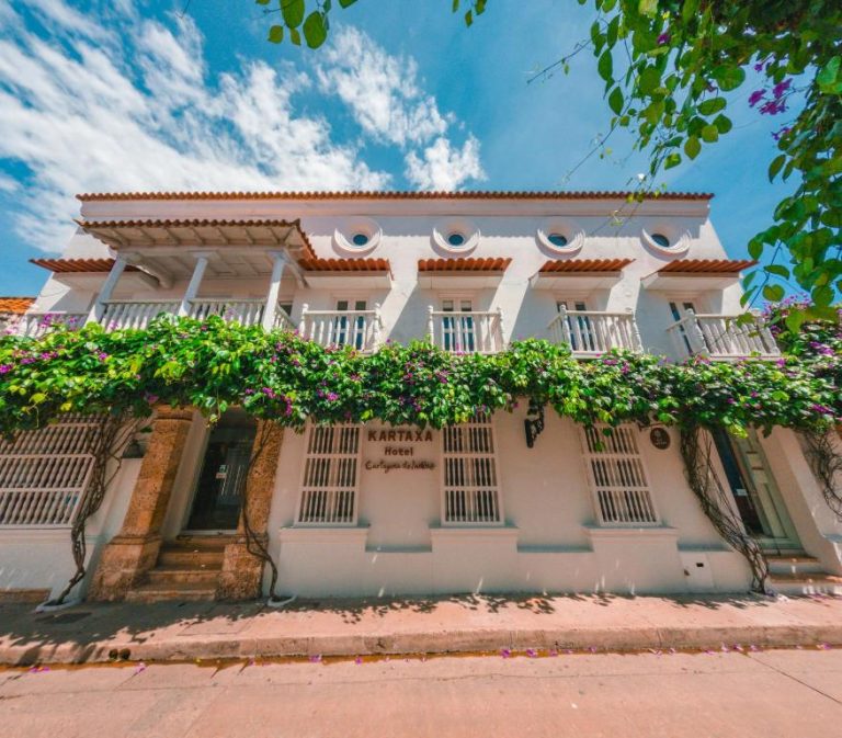 Fachada colonial blanca con buganvilias del Hotel Kartaxa en Cartagena de Indias