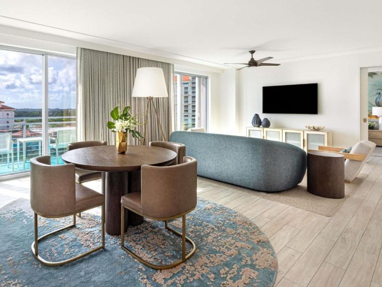 Salón y comedor de suite con vistas panorámicas al complejo en el SLS at Baha Mar