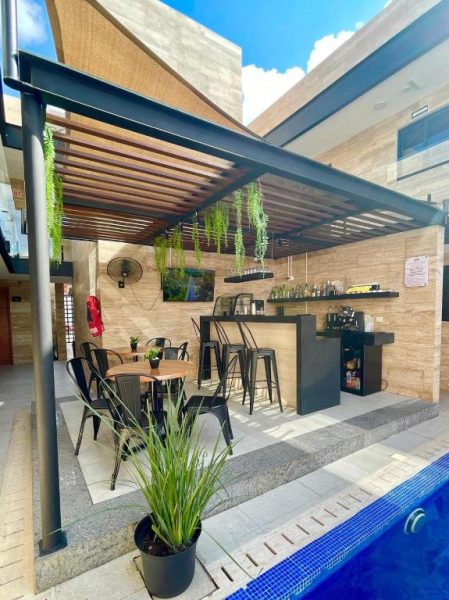 Bar terraza con pérgola y área de descanso junto a la piscina del Hotel 28 Cancun