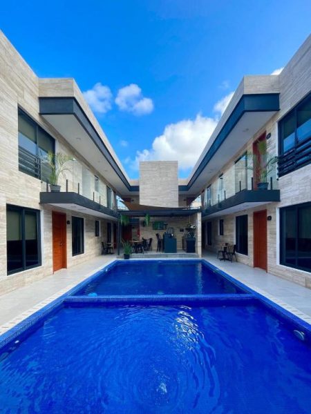 Piscina exterior con alberca azul y vista a las habitaciones del Hotel 28 Cancún