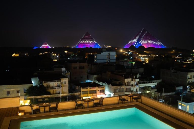 Piscina infinity del Kemet Pyramids View Hotel con vistas nocturnas a las Pirámides de Guiza iluminadas