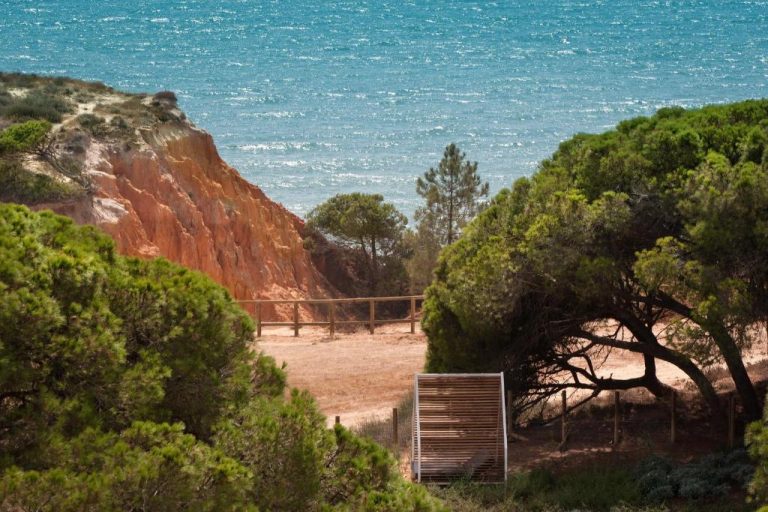 Sendero entre pinos hacia los acantilados rojos y el mar turquesa del EPIC SANA Algarve Hotel