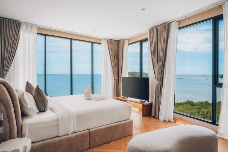 Habitación de lujo con cama doble y ventanales panorámicos con vista al mar en Leva Boutique Hotel