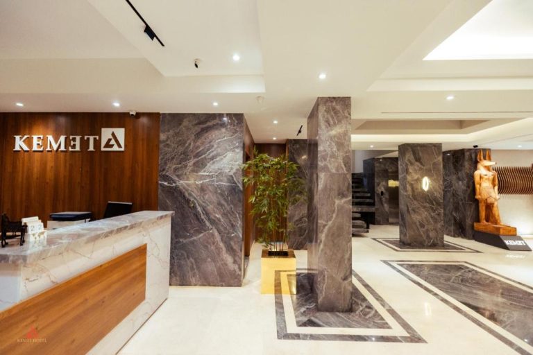 Recepción y lobby de mármol con columnas y estatua egipcia del Kemet Pyramids View Hotel