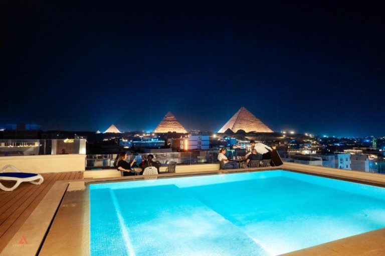 Piscina en azotea del Kemet Pyramids View Hotel con vistas nocturnas a las Pirámides de Giza