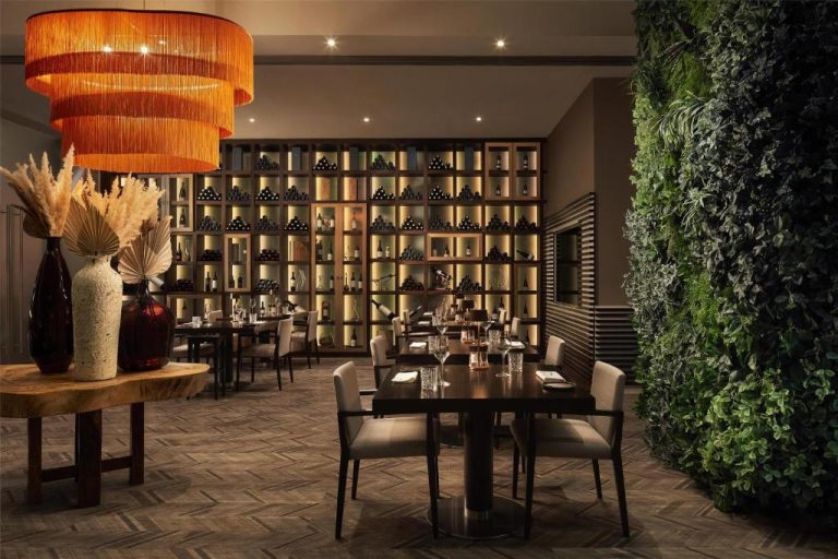 Restaurante del Tivoli Marina Vilamoura con bodega iluminada, jardín vertical y elegante decoración interior