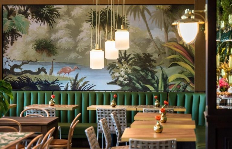 Restaurante del Hotel Eco Boutique Bidasoa con mural tropical, banquetas verdes y lámparas doradas