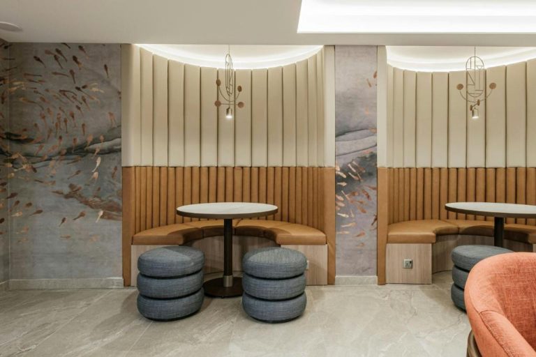 Zona de lounge con booths tapizados y murales decorativos en Courtyard by Marriott Sliema