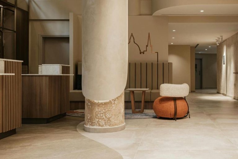 Lobby moderno con columna decorativa y zona de recepción del Courtyard by Marriott Sliema