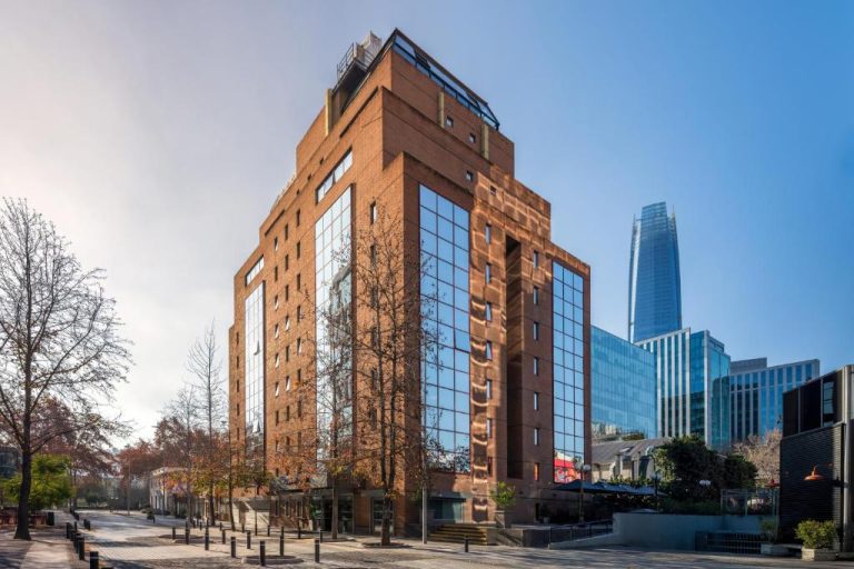 Fachada exterior de ladrillo del Four Points by Sheraton Santiago con rascacielos al fondo