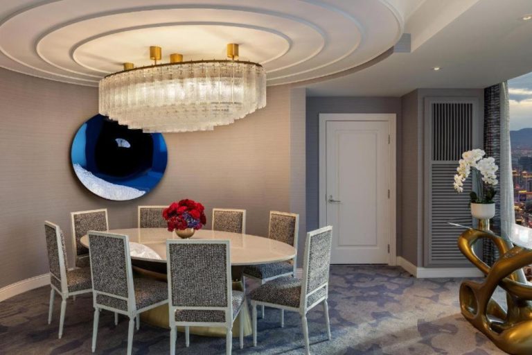 Elegante comedor de suite de lujo con lámpara de cristal y mesa oval en Fontainebleau Las Vegas