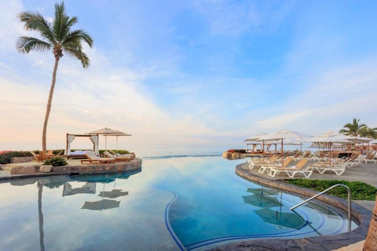 Piscina infinita con tumbonas y palmeras frente al mar en The Club at Hacienda del Mar