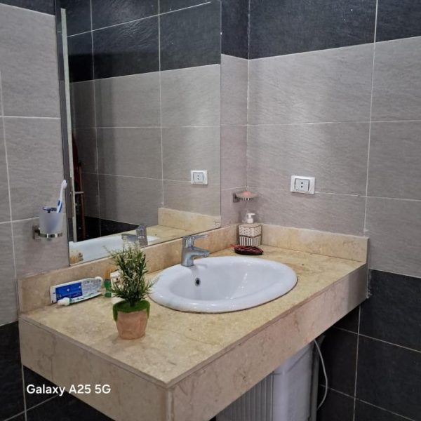 Baño moderno con lavabo de mármol y espejo grande en la Aldea Fanadir Bay Hurghada