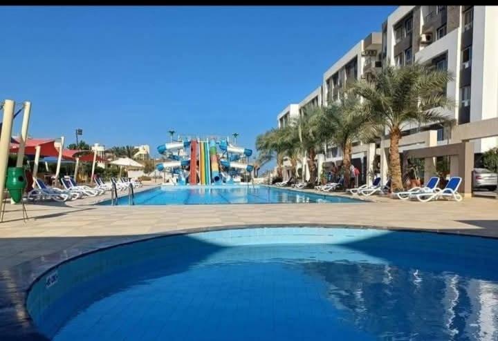 Piscina exterior con toboganes acuáticos de colores en la aldea Fanadeer Bay de Hurghada, Egipto