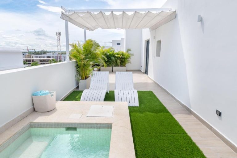 Terraza privada con jacuzzi, tumbonas blancas y pérgola del Corner Penthouse con vistas al mar
