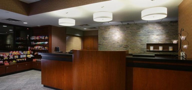 Recepción y lobby elegante con mostrador de madera del hotel The Carriage House e iluminación cálida