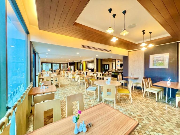 Amplio restaurante interior con mesas y sillas del Phuket Merlin Hotel con vistas panorámicas