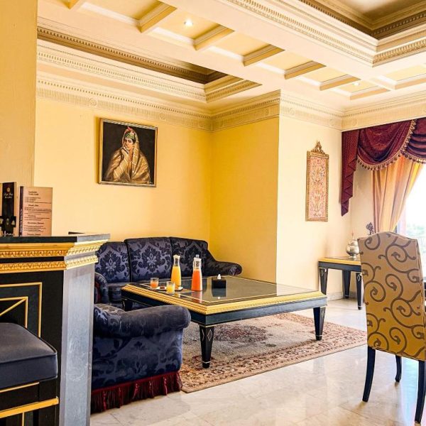 Elegante salón de recepción con sofás azules y decoración árabe lujosa en el Royal Mirage Deluxe