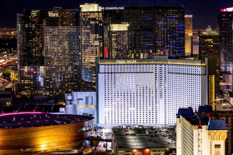 Vista nocturna del hotel The Reserve at Park MGM en Las Vegas Strip con el Cosmopolitan y Vdara al fondo