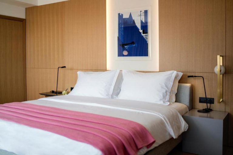 Habitación doble con cama matrimonial y decoración moderna en madera del Hotel Excelsior